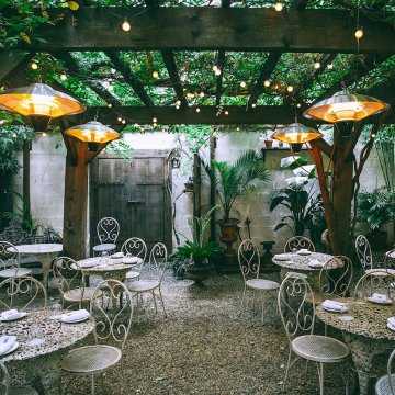 a nice backyard with lots of plants around tables